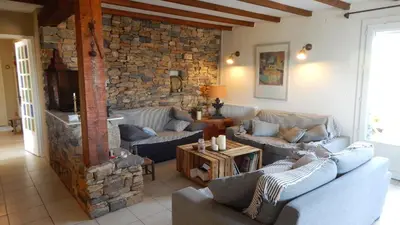 a living room with couches and a stone wall at La Maison de Fafa in Carcassonne