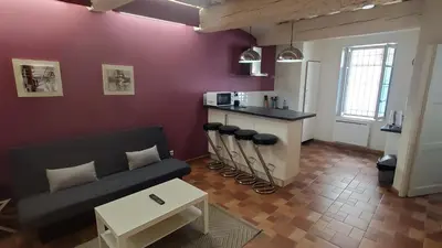 a living room with a couch and a kitchen at REPUBLIQUE Centre in Carcassonne