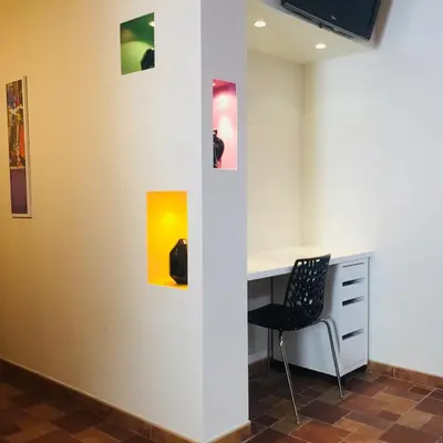 a room with a desk and three paintings on the wall at REPUBLIQUE Centre in Carcassonne