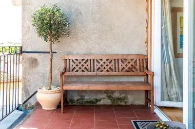 a wooden bench sitting on a porch with a potted plant at Wine Loft, Terrasse et Vue extraordinaire sur la cité médiévale in Carcassonne