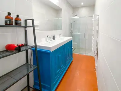 a bathroom with a blue cabinet next to a sink and a tub at Entre Midi - Maison d'Hôtes - B&B in Capestang