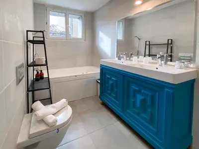 a bathroom with a blue bathroom vanity and a shower at Entre Midi - Maison d'Hôtes - B&B in Capestang