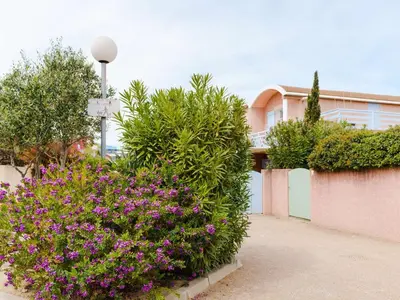 a garden with purple flowers in front of a building at Charmant pavillon 3 chambres avec véranda près plage Grazel – Parking sécurisé - FR-1-409-144 in Gruissan
