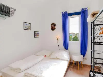 a room with a bed and a window with blue curtains at Charmant pavillon 3 chambres avec véranda près plage Grazel – Parking sécurisé - FR-1-409-144 in Gruissan