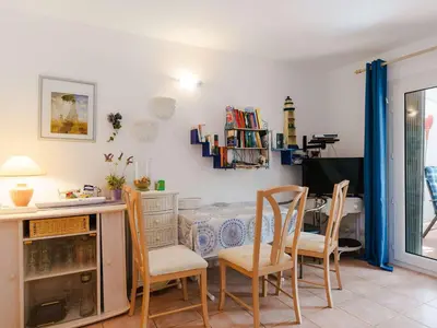 a dining room with a table and chairs at Charmant pavillon 3 chambres avec véranda près plage Grazel – Parking sécurisé - FR-1-409-144 in Gruissan