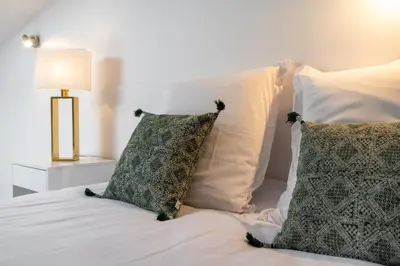 a bed with two pillows and a lamp on it at La suite numéro 1 in Carcassonne