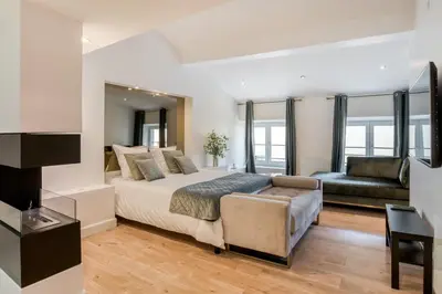 a bedroom with a king sized bed and a couch at La suite numéro 1 in Carcassonne