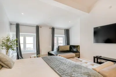 a bedroom with a bed and a couch and a tv at La suite numéro 1 in Carcassonne