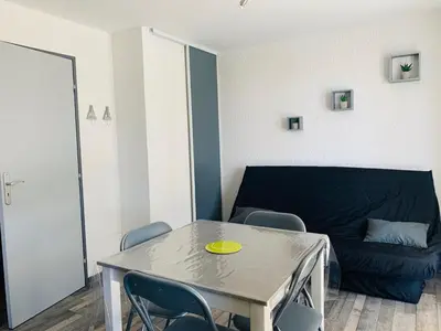 a living room with a table and a couch at La Pinède in Gruissan