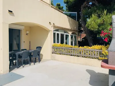 a patio with a table and chairs and a fence at La Pinède in Gruissan
