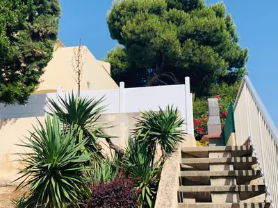 a staircase leading up to a house with palm trees at La Pinède in Gruissan