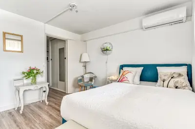 a bedroom with a white bed and a blue headboard at Appartement et Studio Le Méditerranée Port Soleil in Gruissan