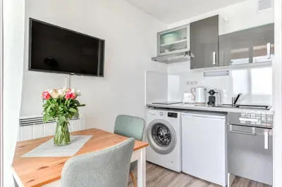 a kitchen with a table with a vase of flowers at Appartement et Studio Le Méditerranée Port Soleil in Gruissan