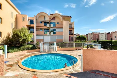 a swimming pool in front of a building at Appartement et Studio Le Méditerranée Port Soleil in Gruissan