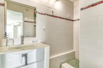 a white bathroom with a sink and a shower at Appartement et Studio Le Méditerranée Port Soleil in Gruissan