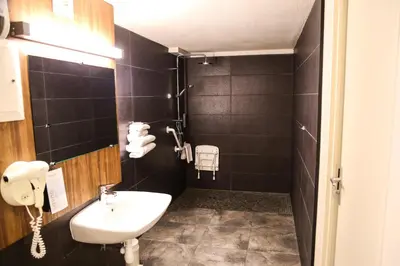 a bathroom with a sink and a phone on the wall at Campanile Narbonne A9/A61 in Narbonne