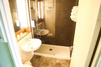 a bedroom with a bed with two lime green pillows at Campanile Narbonne A9/A61 in Narbonne