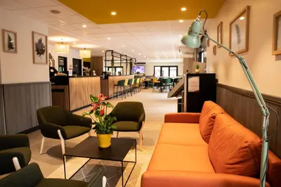 a lobby with orange couches and a table and chairs at Campanile Narbonne A9/A61 in Narbonne