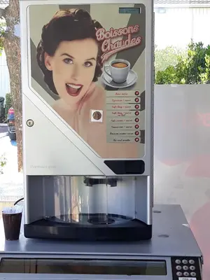 a coffee machine with a sign on top of it at Fasthotel Narbonne in Narbonne