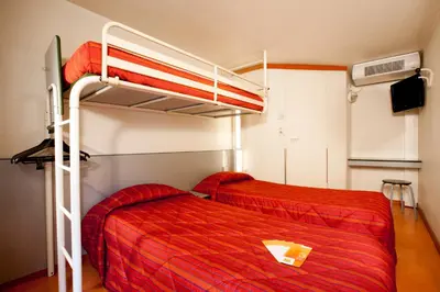 a bedroom with two bunk beds with red sheets at Hôtel Premiere Classe Pamiers in Pamiers