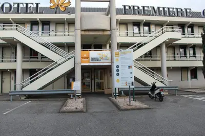 a person riding a scooter in front of a building at Hôtel Premiere Classe Pamiers in Pamiers