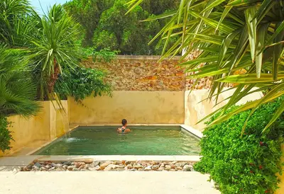 a boy swimming in a swimming pool in a backyard at L'Accent d'ici in Le Somail