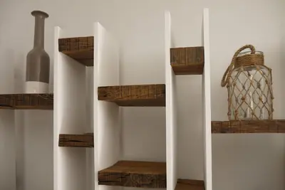 a room with wooden shelves and a basket on the wall at L'Accent d'ici in Le Somail