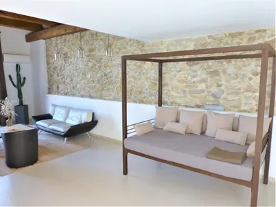 a living room with a bed and a chair at L'Accent d'ici in Le Somail