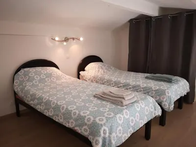 two beds sitting next to each other in a room at Gîte Madeleine in Saint-Nazaire-dʼAude