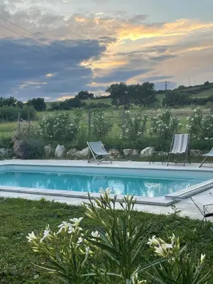 a swimming pool with two lawn chairs at Gîte de Genty in Cenne-Monestiès