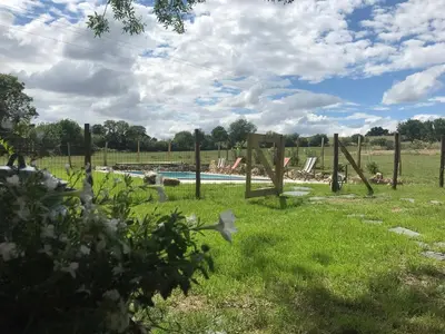 a pool in a field with a fence and flowers at Gîte de Genty in Cenne-Monestiès