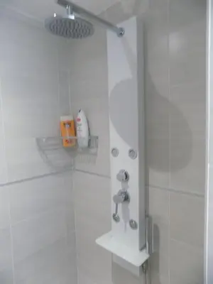 a bathroom with a shower with white tiles at Villa VAYA in Villemoustaussou