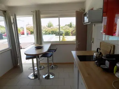 a kitchen with a counter and a table and a window at Villa VAYA in Villemoustaussou