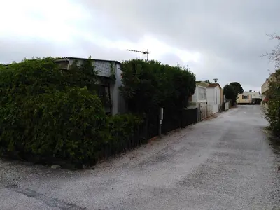 a street with a fence next to a house at camping le pavillon in Sigean