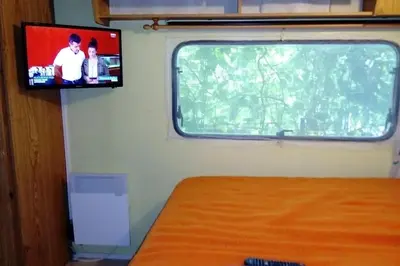 a tv on a wall next to a window at camping le pavillon in Sigean