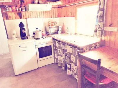 a kitchen with white appliances and a wooden floor at camping le pavillon in Sigean