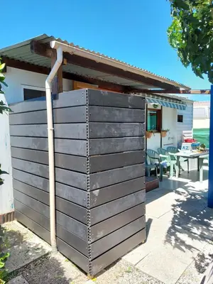 a wooden privacy fence with a gazebo at camping le pavillon in Sigean