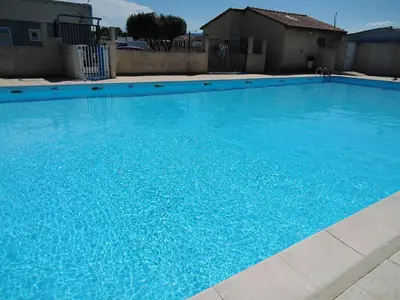 a large swimming pool with blue water at camping le pavillon in Sigean
