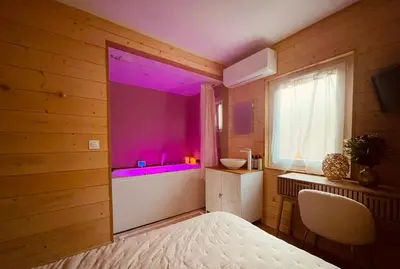 a bedroom with a large window with purple lighting at Caprice Gruissanais Spa - T2 plage des chalets in Gruissan