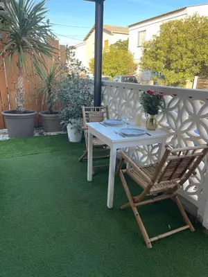 a white table and chairs on a patio at Caprice Gruissanais Spa - T2 plage des chalets in Gruissan
