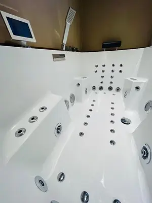 a bathtub in a room with a computer on the wall at Caprice Gruissanais Spa - T2 plage des chalets in Gruissan