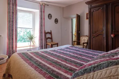 a bedroom with a bed with a colorful blanket on it at Domaine de Malouziès in Fontiers-Cabardès