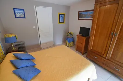 a bedroom with a bed with blue pillows on it at Domaine de Malouziès in Fontiers-Cabardès