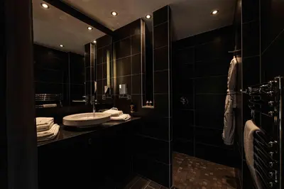 a black bathroom with a sink and a mirror at Hôtel Le Parc - La Table de Franck Putelat in Carcassonne
