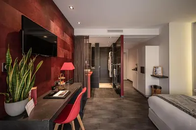 a hotel room with a bed and red walls at Hôtel Le Parc - La Table de Franck Putelat in Carcassonne