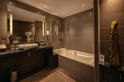 a bathroom with a sink and a bath tub and a sink at Hôtel Le Parc - La Table de Franck Putelat in Carcassonne