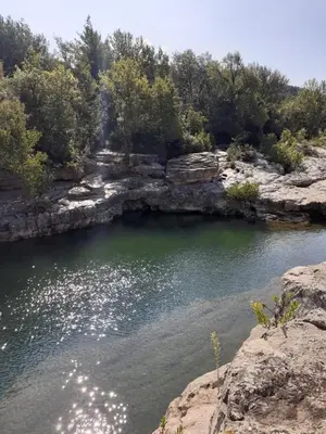 a body of water with rocks and trees at Chambre privée au coeur d'une pinède dans un quartier résidentiel in Lézignan-Corbières