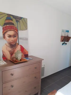 a painting of a girl sitting on top of a dresser at Chambre privée au coeur d'une pinède dans un quartier résidentiel in Lézignan-Corbières