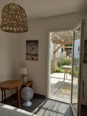 a room with a table and a glass door at Chambre privée au coeur d'une pinède dans un quartier résidentiel in Lézignan-Corbières