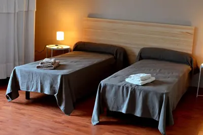 a hotel room with two beds and a table at Au Perchoir in Caunes-Minervois